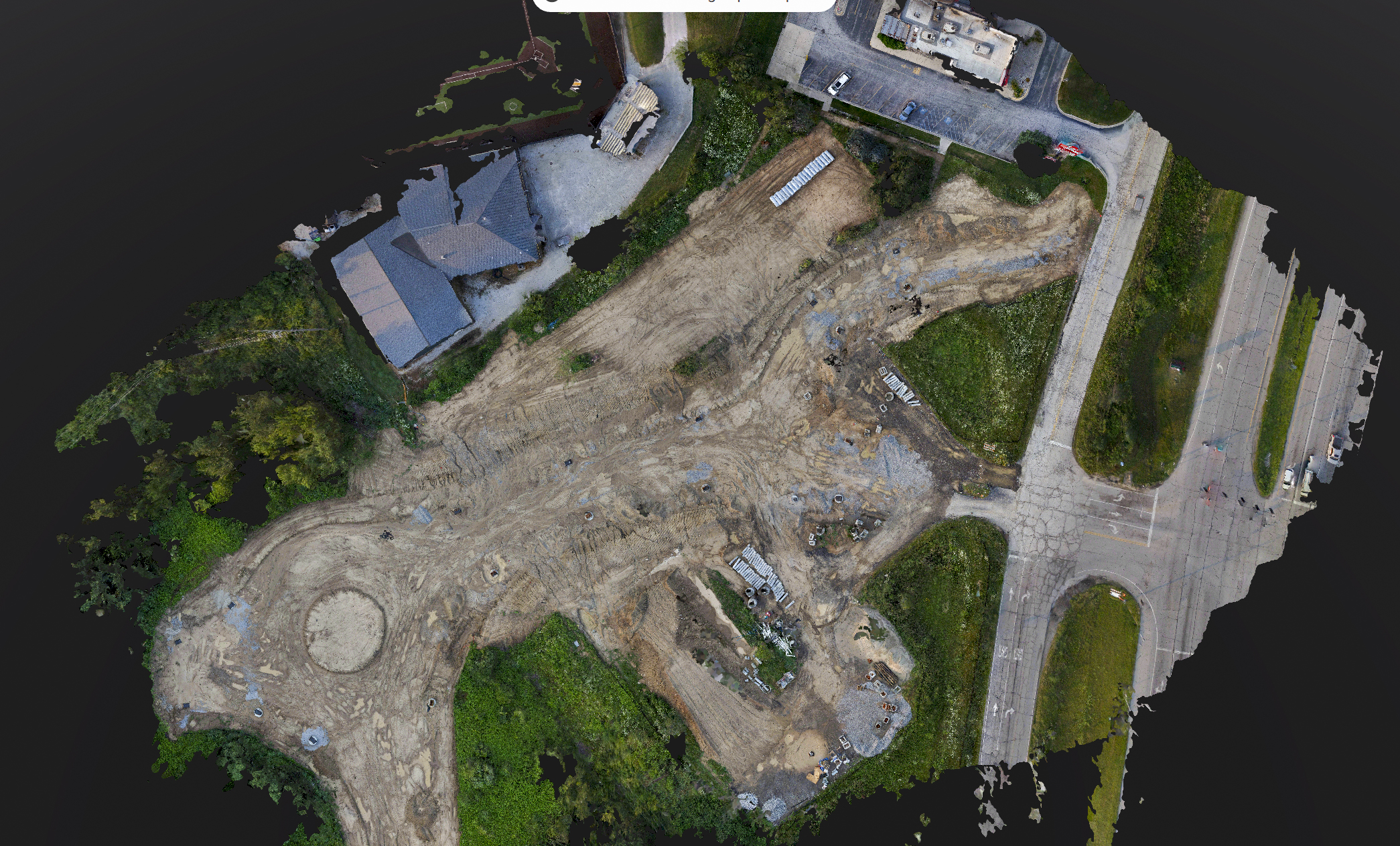 Top-down aerial orthomosaic of an earthwork site captured by MIR, the basis for mapped contours, site limits, and vector overlays