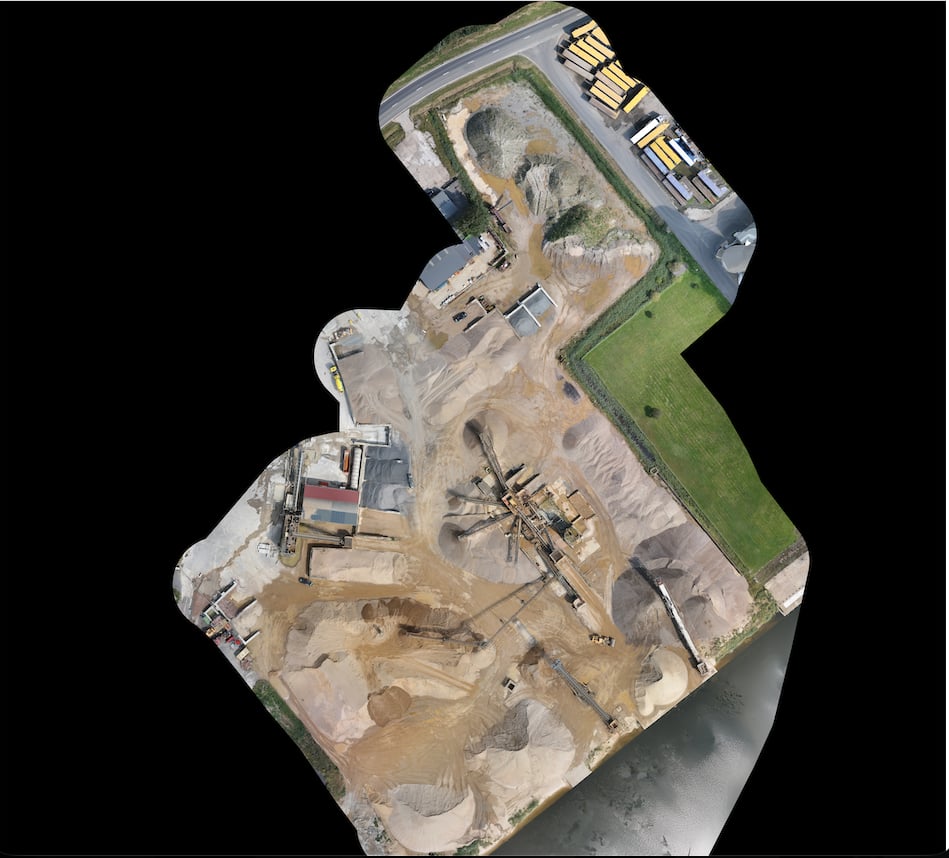 Top-down georeferenced orthomosaic of an aggregate processing yard showing stockpiles, conveyors, and plant equipment